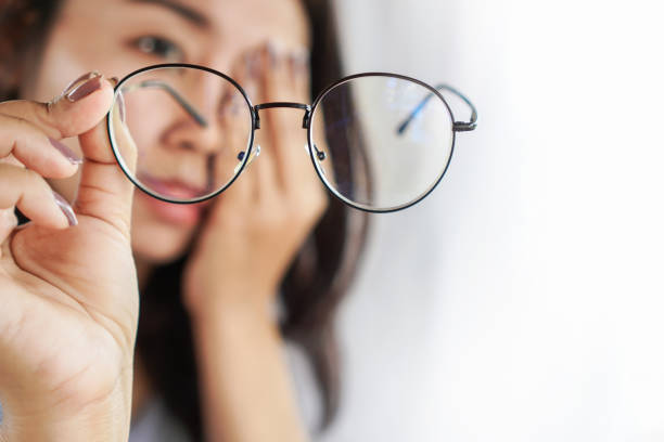 Asian woman hand holding eyeglasses having problem with eye pain, blur vision Asian woman hand holding eyeglasses having problem with eye pain, blur vision window blinds photos stock pictures, royalty-free photos & images