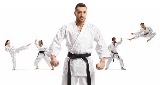 karate master with black belt standing in front of men and women practicing martial arts - extreme sports karate sport exercising imagens e fotografias de stock