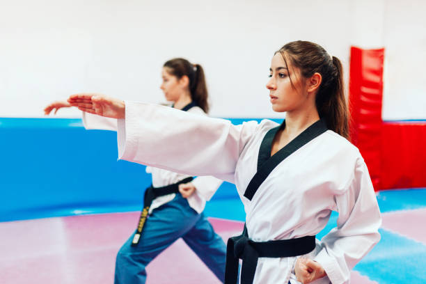 dos mujeres jóvenes practican taekwondo en un centro de formación - martial arts women tae kwon do black belt fotografías e imágenes de stock