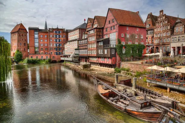 Luneburg, Germany - July 4, 2019: Old Luneburger harbor with traditional houses and a historical boat in the old part of Luneburg, Germany on July 4, 2019