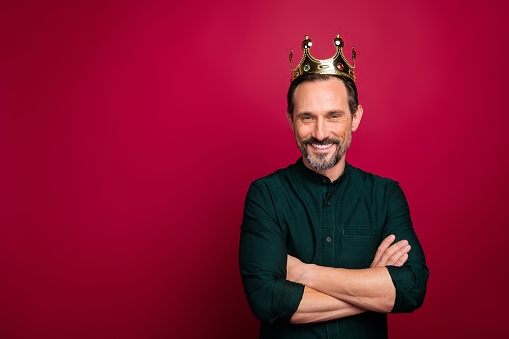 Photo of brown haired stylish trendy man with crown on head smile toothy, satisfied wearing golden accessory isolated near empty space vivid color background