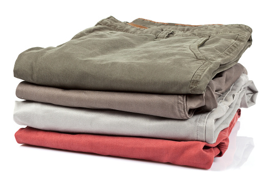 Neatly folded stack of mens chino pants with labels