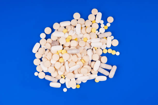 青い背景に医療薬の山 - perscription capsule frame pill ストックフォトと画像