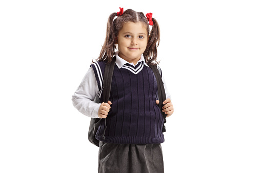 Schoolgirl in a uniform looking at the camera isolated on white background