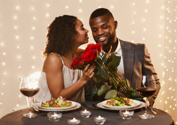 dankbare schwarze dame hält bund von rosen, küssen ihren freund - food and drink holidays and celebrations people valentines day stock-fotos und bilder