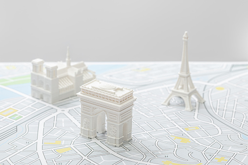 selective focus of small figurines on map of paris isolated on grey