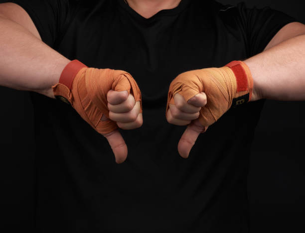 istock athlete in black uniform and hands rewound with textile orange bandage shows gesture dislike 1201655734