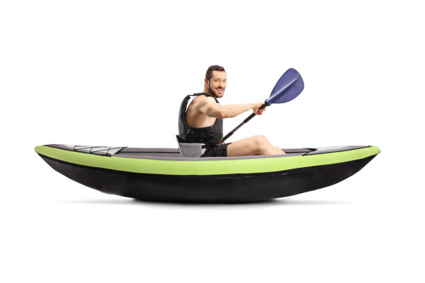 istock Young man paddling a kayak and smiling at the camera 1201655743