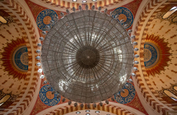 A captivating upward view of a dome constructed with steel beams and glass, beautifully lit by ambient sunlight filtering through.