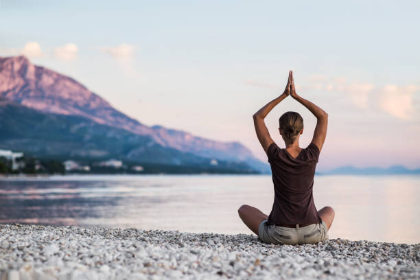 istock Woman is practicing yoga at sunset. Meditation and harmony concept 1201657365
