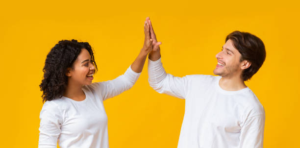istock Positive interracial couple clapping hands, giving high five to each other 1201657471