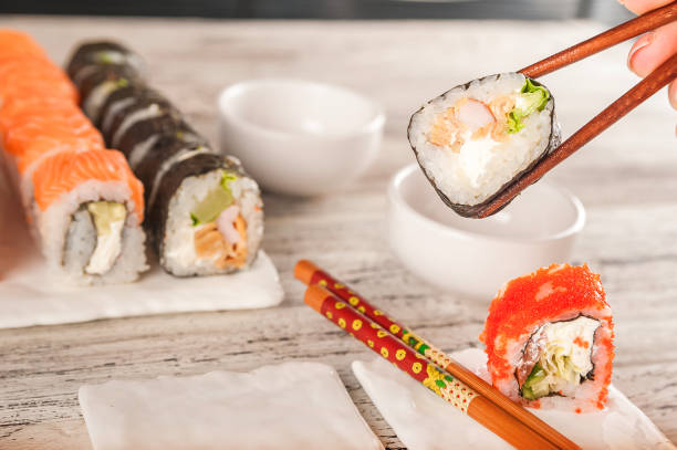 istock Closeup table setting by February 14th. Romantic dinner for two in chinese style and copy space. Rolls are held with chopsticks. 1201657804