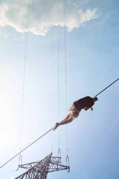 istock Young Caucasian slackline man practicing slackline against the sky on a clear summer day 1201659089