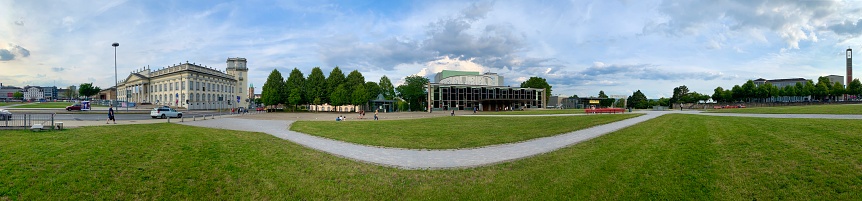 Kassel, Germany - August, 5 - 2019:  View of the Staatstheater, state theater, building in center. On the left side the Museum Fridericanum. People walking by in the public park close to the center of the city.