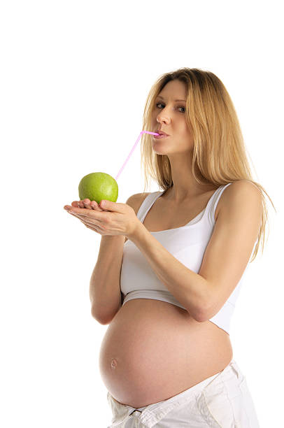 istock pregnant woman drinking juice from apple 120166280