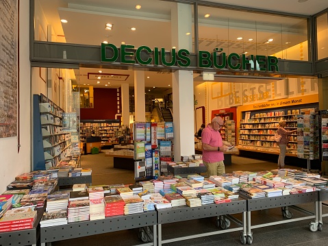 Hildesheim, Germany - August, 5 - 2019:  Books shop DECIUS BÜCHER seen from a public street into the ground level. People looking for books at the displays.