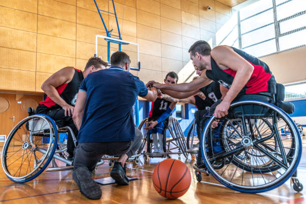 istock Disabled basketball players clasping hands with coach 1201663327