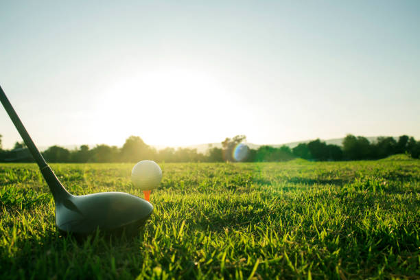 clubs de golf et balles de golf sur une pelouse verte dans un beau terrain de golf - golf golf swing sunset golf course photos et images de collection