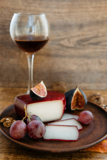 istock Plate with crafted cheddar cheese, fig, grape and red wine 1201667348