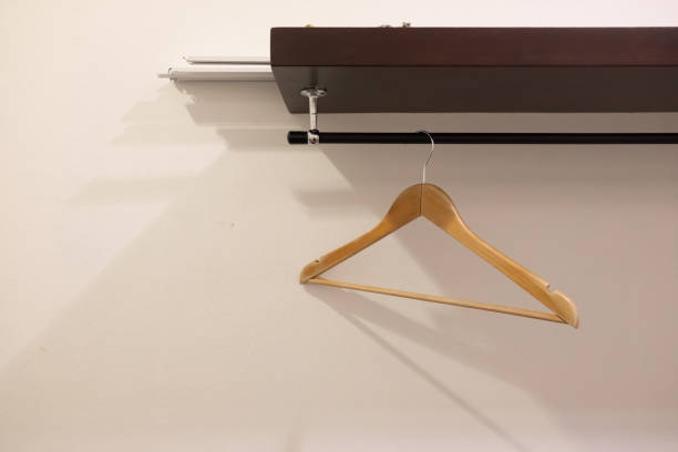 istock Empty wooden clothes hangers hanging on a metal bar. 1201668764