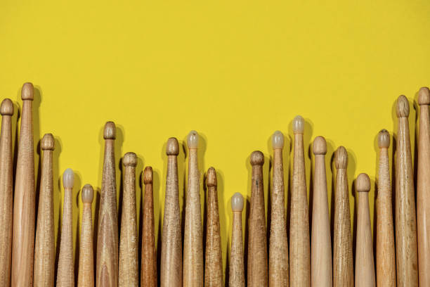 Many wooden drumsticks on a yellow background - Percussion instrument