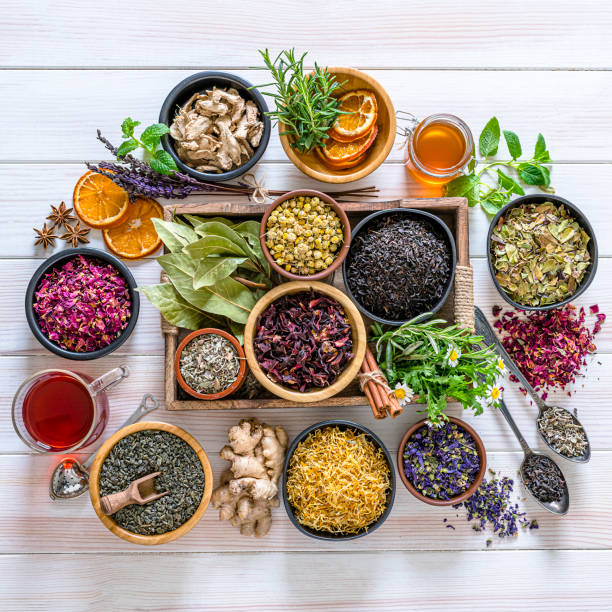 gran variedad de hojas de té seco multicolor y flores disparadas desde arriba en la mesa blanca - infusión té bebida fotografías e imágenes de stock