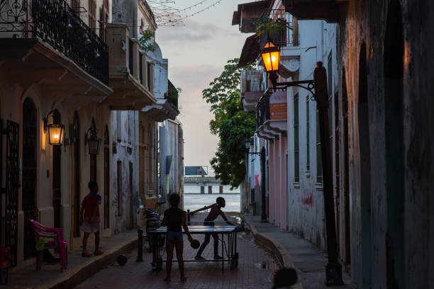 Silhouettes of kids playing table tennis in the character-rich streets of Casco Antiguo in early evening light stock photo