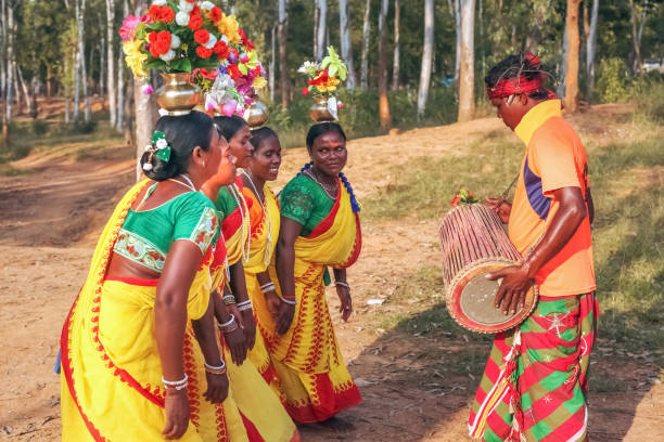 mann spielt ein musikinstrument, während stammesfrauen volkstanz in shantiniketan west bengalieren - india indian culture traditional culture dancing stock-fotos und bilder