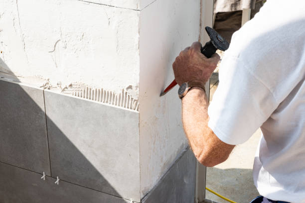 istock the mason prepares the wall with a chisel before laying a ceramic tile 1201679461