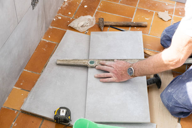 istock the tiler measures the tile before cutting it 1201679489