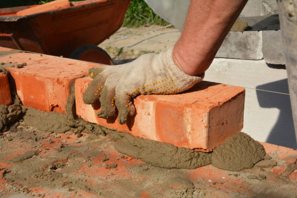 istock Bricklayers hands in masonry gloves bricklaying house wall. Bricklaying,  Masonry, Brickwork close up 1201679757