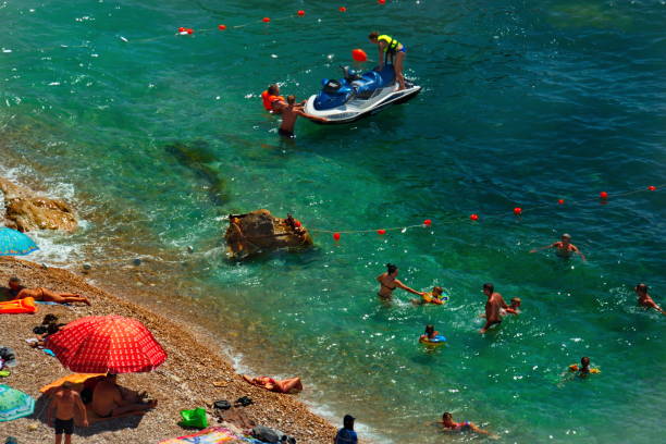 Balaklava. Republic Of Crimea. Russia. August 12, 2018. Many tourists sunbathe on the rocky shore and swim in the waters of the Black sea.