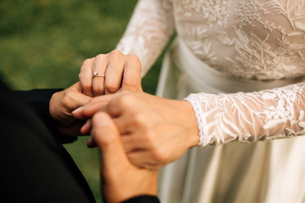 istock Newlywed couple holding their hands together 1201681331