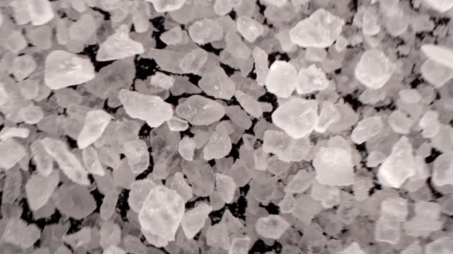 Close up of salt grains in the air on black background