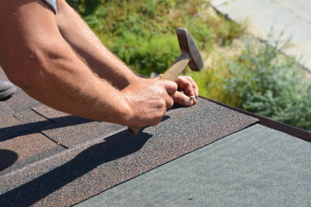istock Roofer hands installing asphalt shingles on house construction roof corner with hammer and nails in motion.  Roofing Construction Photo. 1201682748