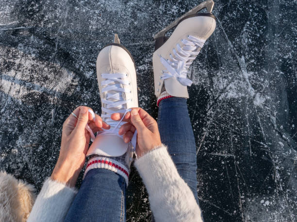 молодая женщина на замерзшем озере на коньках на закате готовитс�я повеселиться и насладиться зимними каникулами - people cold frozen unrecognizable person стоковые фото и изображения