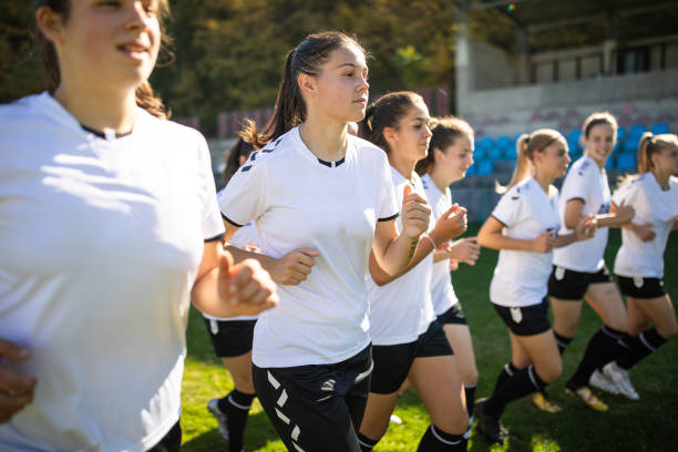 istock Woman soccer team running on training grounds 1201684080
