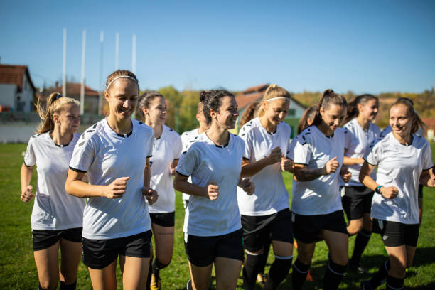 Woman soccer team running on training grounds
