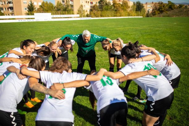 istock Female soccer team huddling with coach before training 1201684924