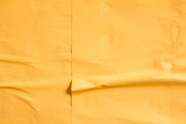 istock Orange crumpled poster on billboard. Orange paper placard texture background. 1201690460