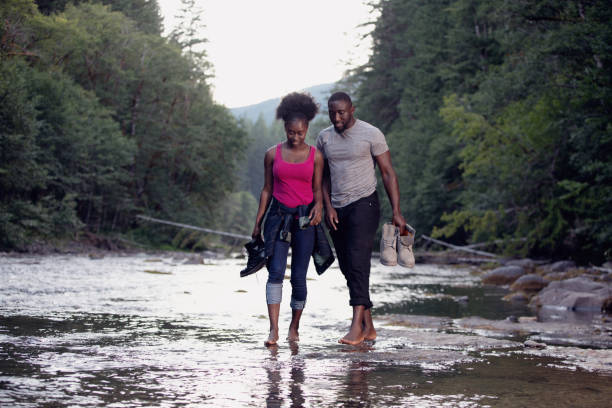 A young couple smiling and enjoying a care free hike along a riverbed