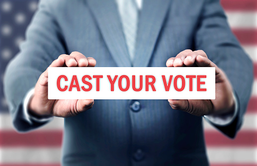 Man hold Cast your vote message with american flag on background