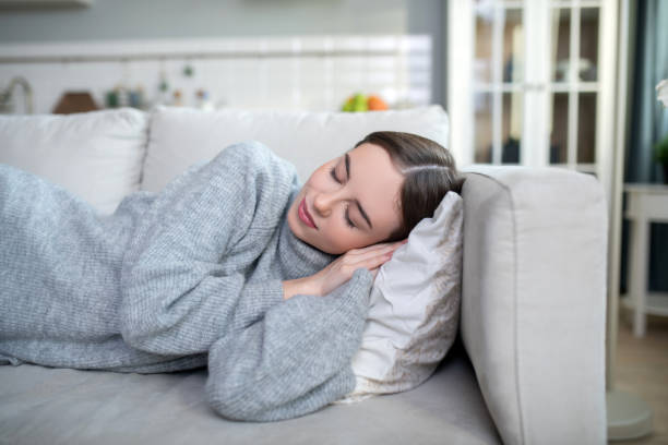 istock Young girl in a grey sweater sleeping calmly 1201694992