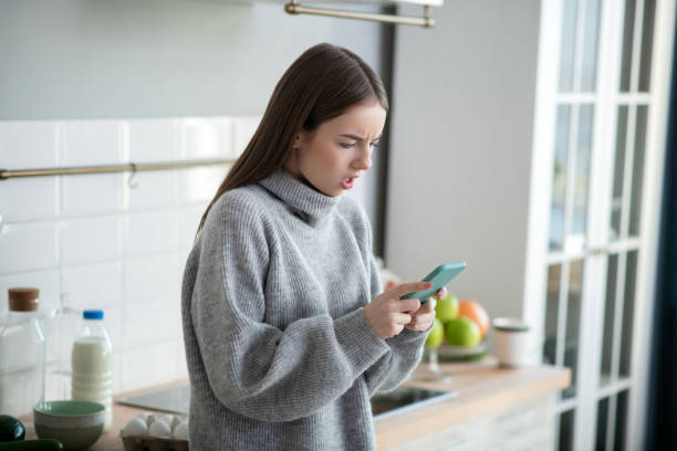 istock Dark-haired girl in a grey sweater looking annoyed 1201695265