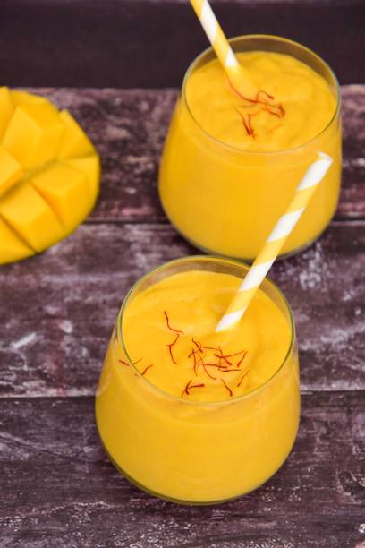 istock Mango Lassi, Indian popular summer drink served in glass garnish with saffron 1201695675