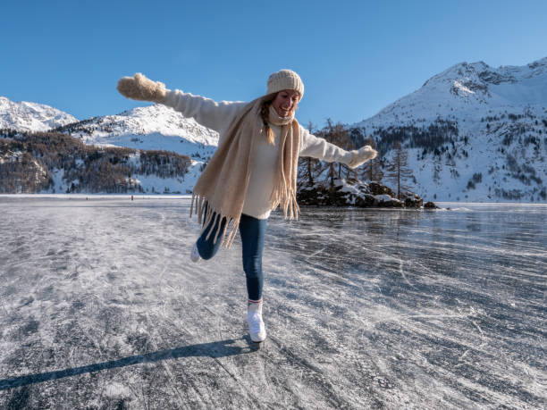Young woman ice skating on frozen lake at sunset Young woman ice skating on frozen lake at sunset having fun and enjoying winter vacations graubunden canton stock pictures, royalty-free photos & images