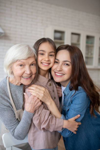 istock Three happy women hugging together in the kitchen. 1201703599