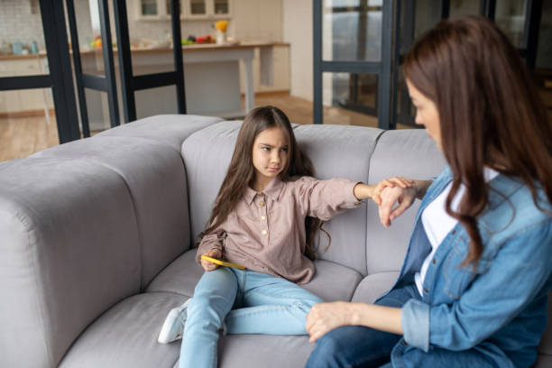 istock Serious daughter with a smartphone in hand looking at mom. 1201703663