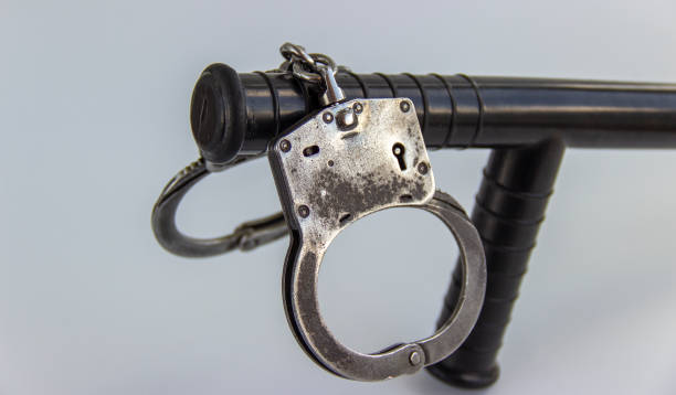 istock real police handcuffs and baton isolated on white background 1201706928