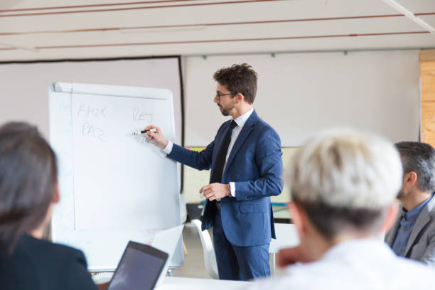 istock Confident speaker in eyeglasses talking near whiteboard 1201708174